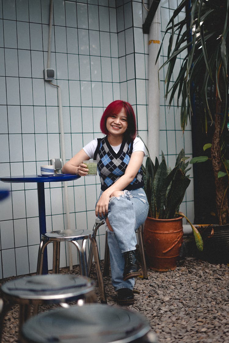 Smiling Girl Sitting In Bar On Outdoor Terrace