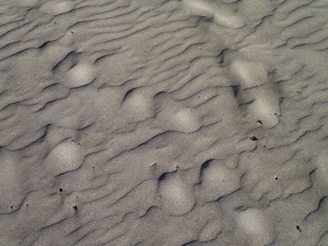 Detailed view of rippled sand patterns on a beach, showcasing natural textures.