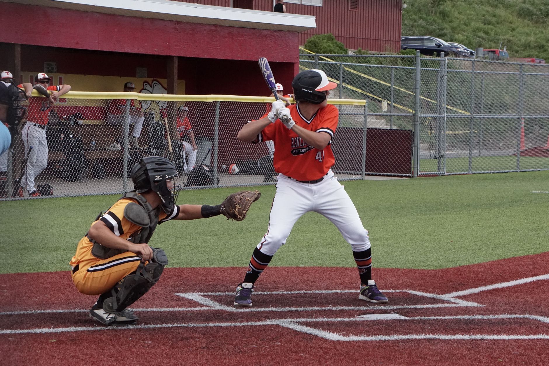 Dynamic shot of a baseball game with a batter poised to hit and a catcher ready for action.