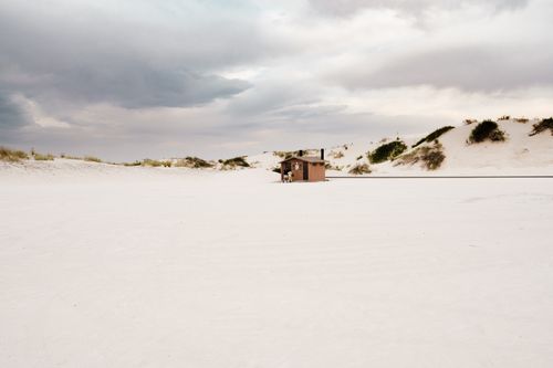 Free Wooden hut amid the vast white sand dunes of New Mexico under a cloudy sky. Stock Photo