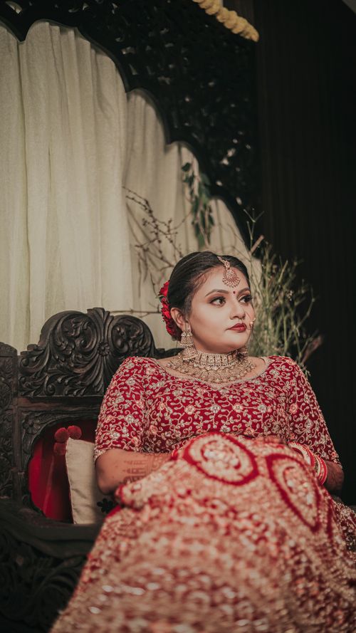 Free Stunning portrait of a bride in a red and gold traditional Indian dress with intricate embroidery. Stock Photo