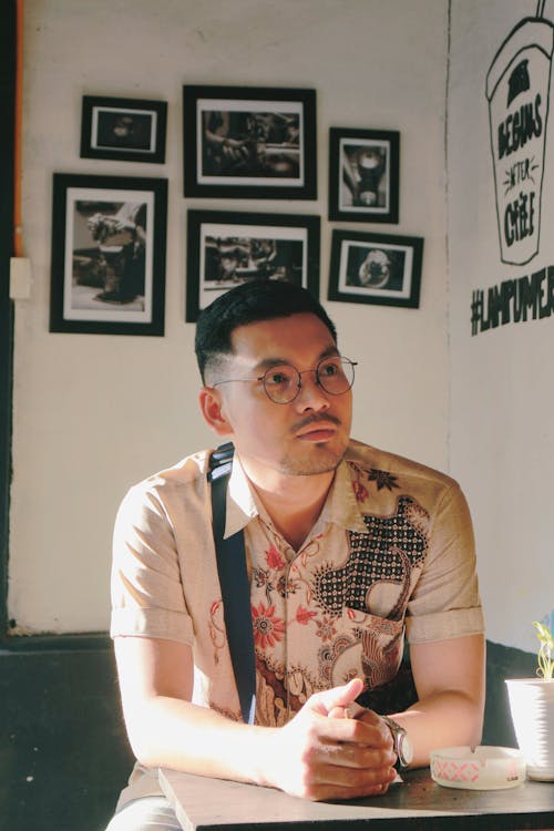 Free Man Wearing Eyeglasses Sitting at a Coffee Shop Stock Photo