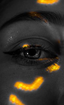 Intense close-up of a human eye, enhanced by vivid lighting effects and unique shadow patterns.