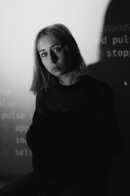 Monochrome portrait of a woman with projected text shadows creating a mysterious ambiance.
