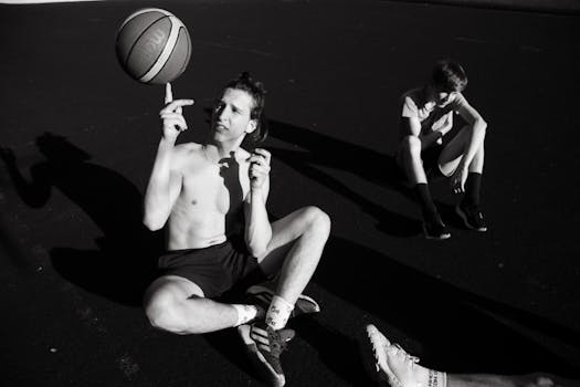 Two young men enjoying a casual street basketball game, captured in black and white.