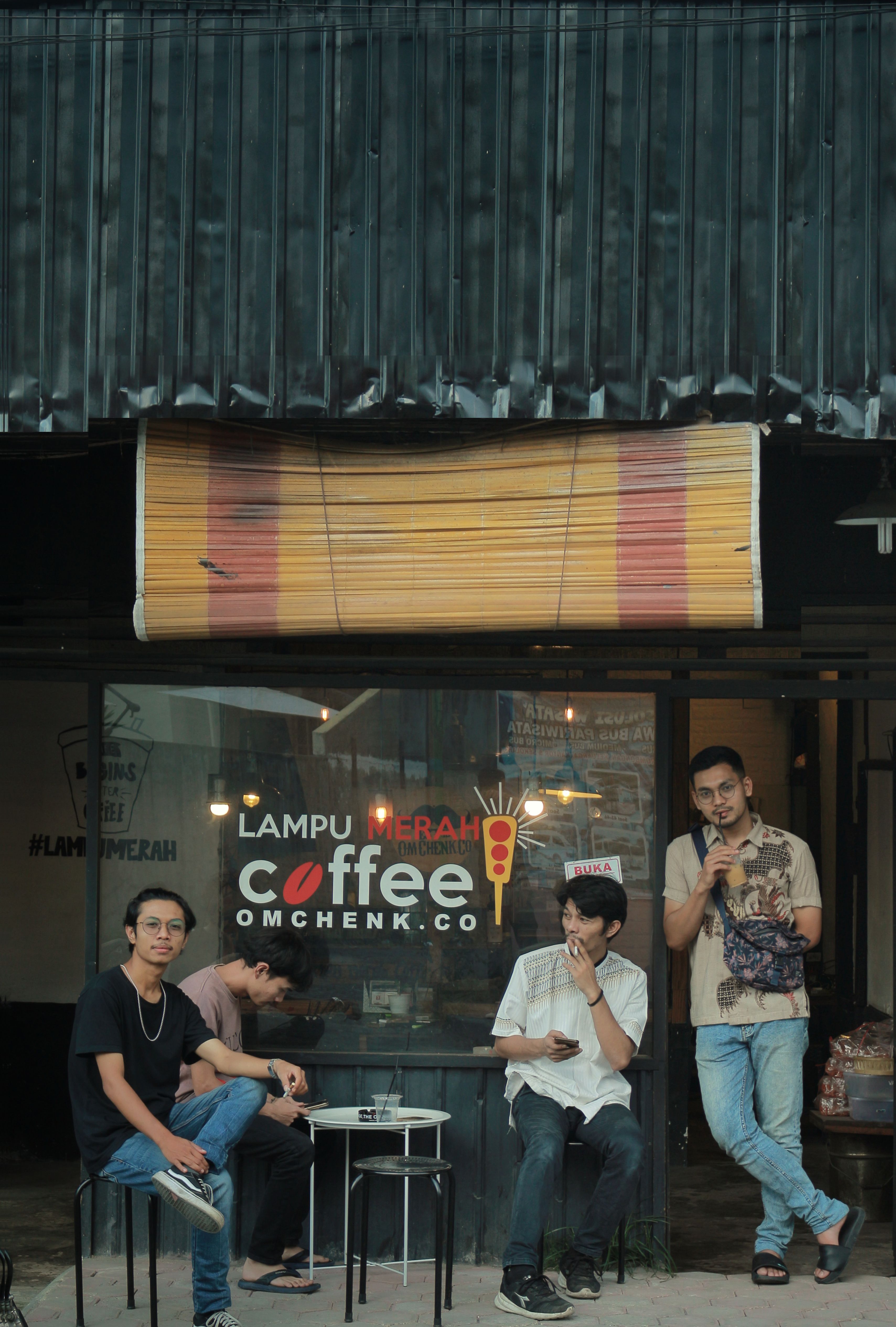 A group of men socializing outside a trendy coffee shop.
