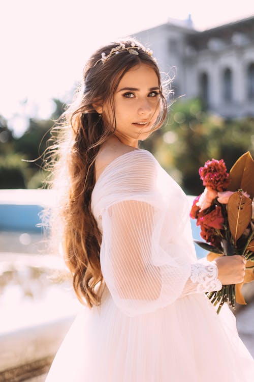 Beautiful Woman in White Gown Holding Bouquet of Flowers 
