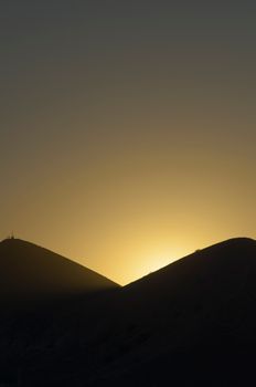 A stunning silhouette of mountains against a golden sunset in Koktebel, creating a serene atmosphere.