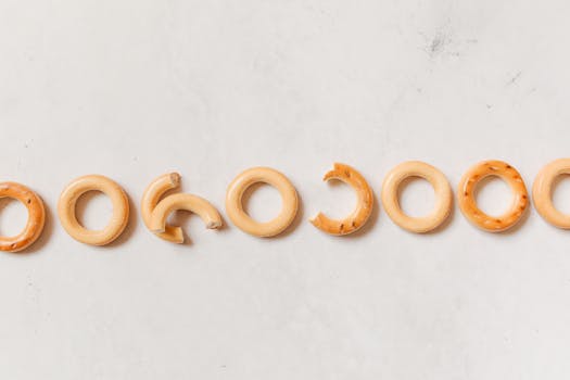 Rows of crispy sushki bread rings lined up on a white background, top view.