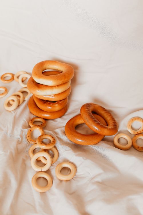 Free Close-up of stacked and scattered traditional Russian Baranki pastries on a beige background. Stock Photo