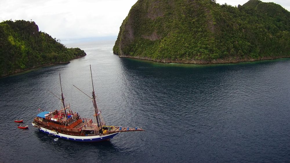 Velero phinisi tradicional de madera anclado entre karsts de Raja Ampat