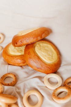 Close-up of traditional Russian vatrushki and baranki pastries arranged artfully on fabric.