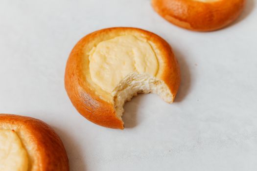 Close-up of traditional Russian vatrushka pastries with creamy filling on parchment.
