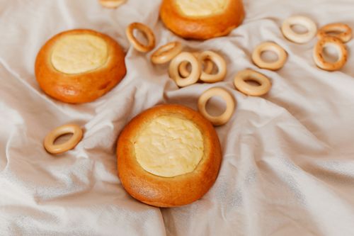 Free Close-up of baked vatrushka and sushki on white cloth, perfect for food blogs. Stock Photo