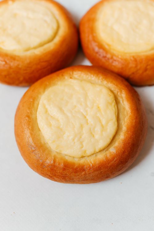 Free Delicious close-up of three Russian vatrushki pastries with creamy cheese filling. Stock Photo