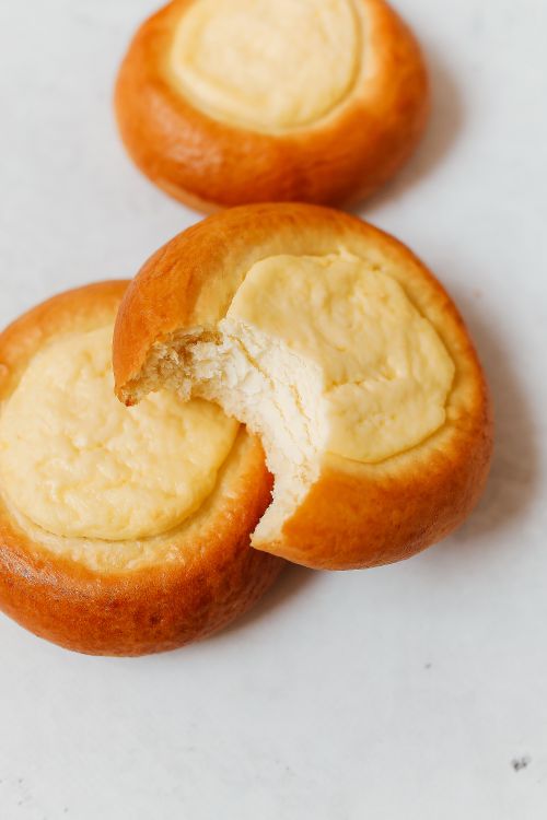 Free Close-up of traditional Russian vatrushki pastries with creamy filling on a light background. Stock Photo