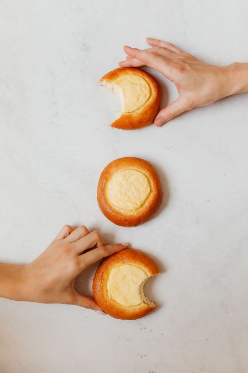 Free Close-up of hands holding traditional Russian vatrushki pastries on white background. Stock Photo