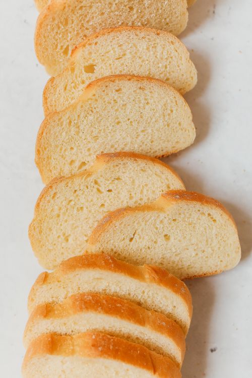 Free Top view of freshly sliced homemade bread on a white background. Perfect for baking themes. Stock Photo