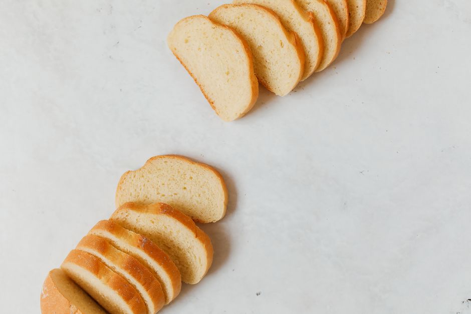 Close-up of sliced white bread arranged on a marble surface, showcasing texture and freshness.