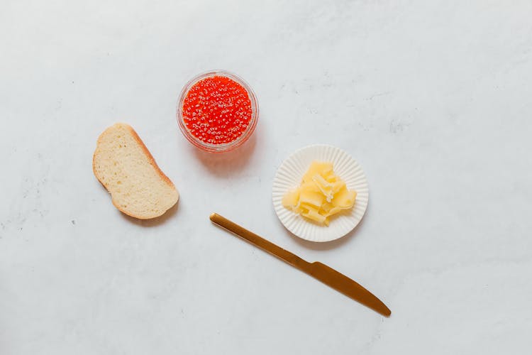 A Sliced Bread Near The Caviar And Butter On A White Surface