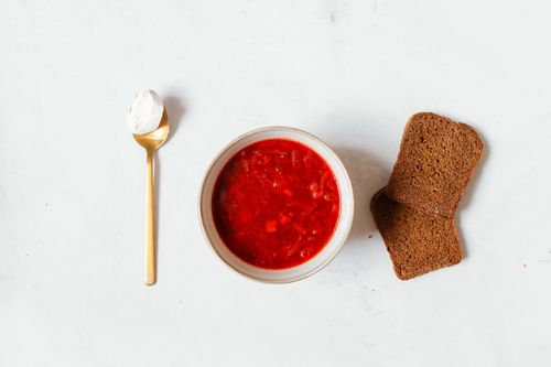Free Flat lay of traditional borscht with rye bread on a marble surface, perfect for food-related content. Stock Photo