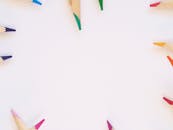 白色背景上，彩色铅笔充满活力地排列成圆圈，呈现顶视图