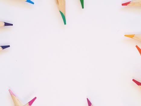 白色背景上，彩色铅笔充满活力地排列成圆圈，呈现顶视图