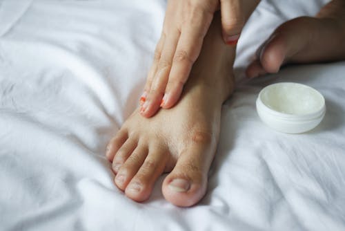 Free Close-Up Shot of a Person Applying a Petroleum Jelly on a Foot Stock Photo