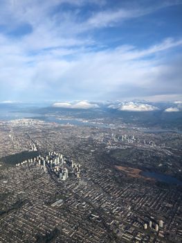 A breathtaking aerial view of Richmond, BC, showcasing the cityscape and snow-capped mountains.