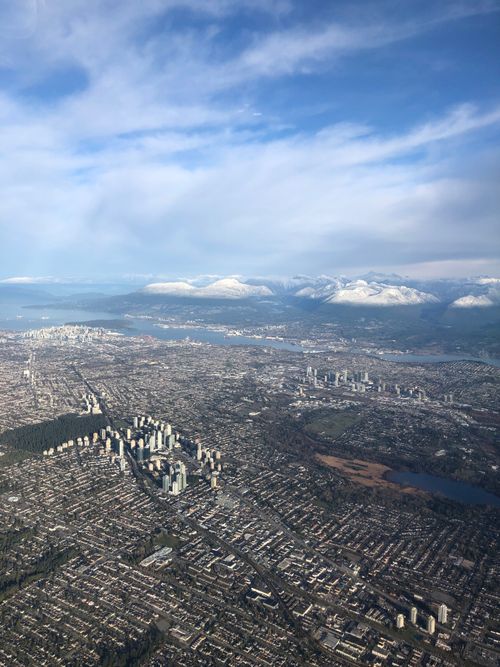 Free A breathtaking aerial view of Richmond, BC, showcasing the cityscape and snow-capped mountains. Stock Photo