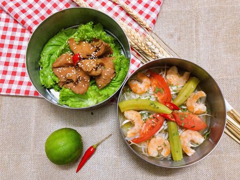Top view of shrimp and vegetable dish with lettuce and chicken, emphasizing fresh Asian flavors.