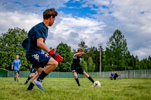 Young athletes engaged in an energetic soccer game outdoors on a grassy field.
