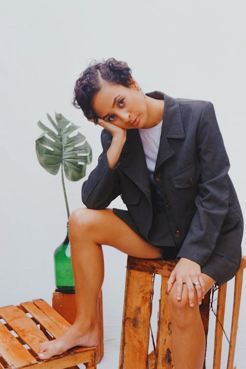 Boy in Black Suit Jacket Sitting on Brown Wooden Chair