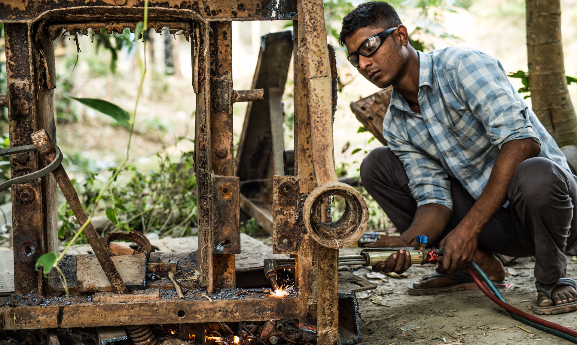 A Man using a Welding Machine on a Scrap Metal