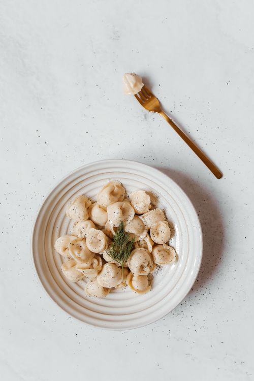 Free Top view of freshly cooked dumplings served on a plate with a fork. Stock Photo