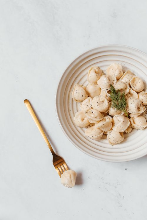Free Delicious dumplings served with fresh dill on a plate. Perfect for food enthusiasts. Stock Photo