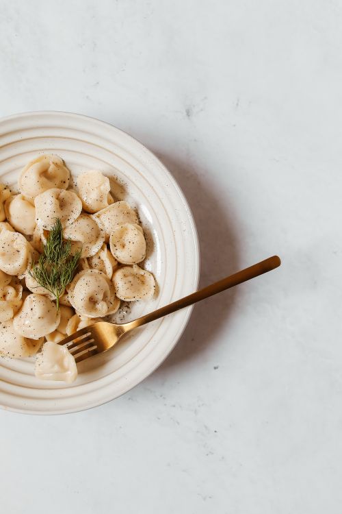 Free Top view of dumplings garnished with dill served elegantly on a white plate. Stock Photo