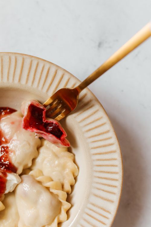 Free Close-up of homemade vareniki with berry filling and red sauce on a plate. Stock Photo