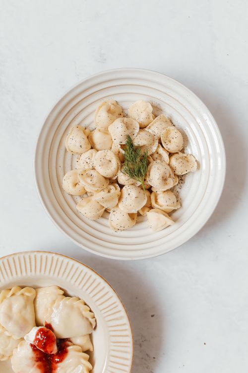 Free Top view of traditional dumplings on plates, showcasing Russian cuisine. Stock Photo