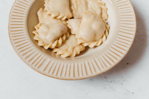 Free Delicious homemade vareniki dumplings served on a rustic ceramic plate. Perfect for food photography. Stock Photo