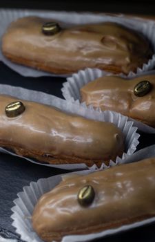 Close-up of mouthwatering coffee eclairs with icing, perfect for dessert lovers.