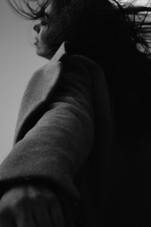 Free Artistic monochrome photo of a woman in motion, wearing a coat. Stock Photo