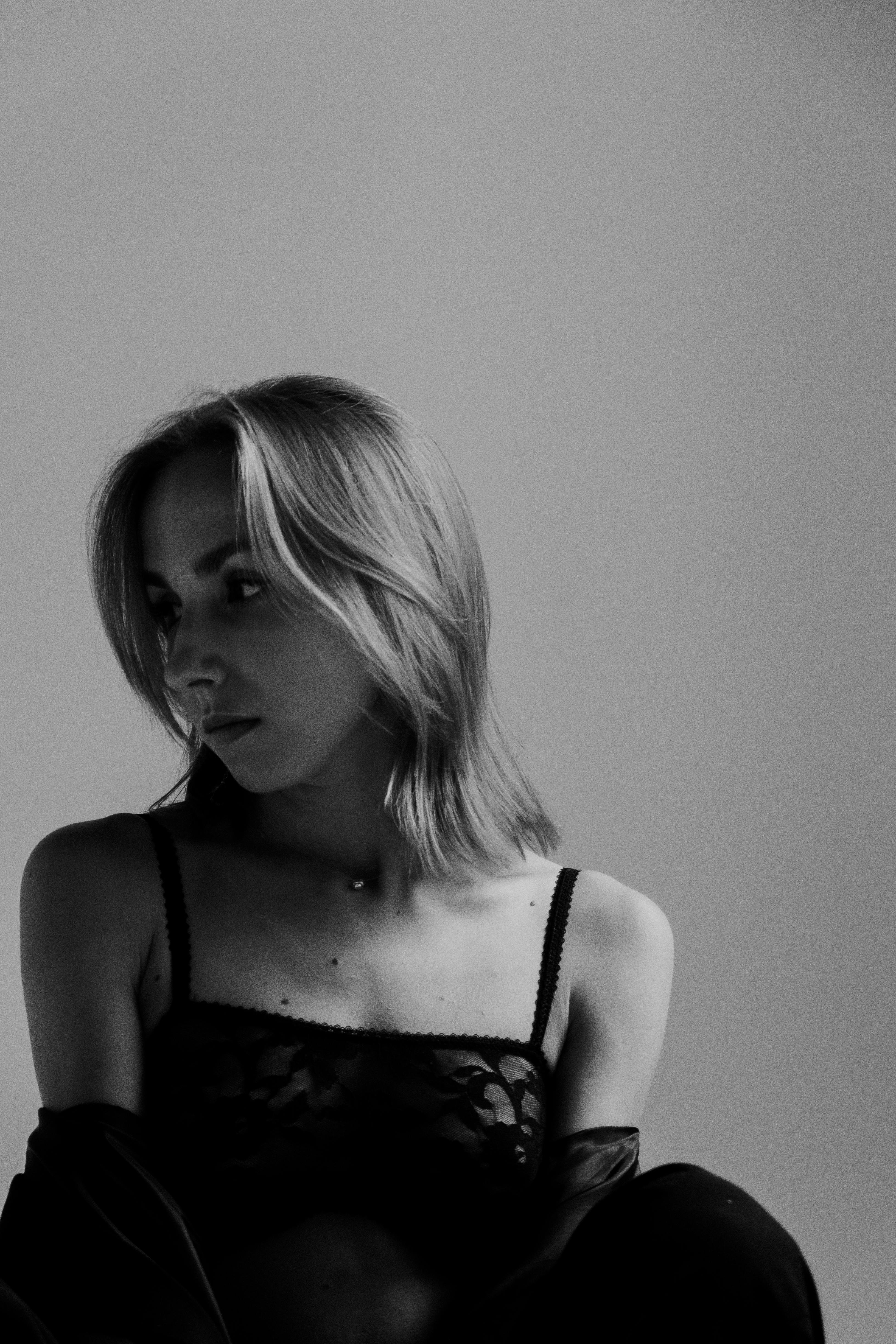 Sophisticated black and white portrait of a woman looking sideways, exuding elegance.