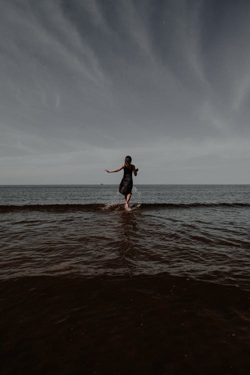 Fotobanka s bezplatnými fotkami na tému čierne šaty, morský breh, plávanie