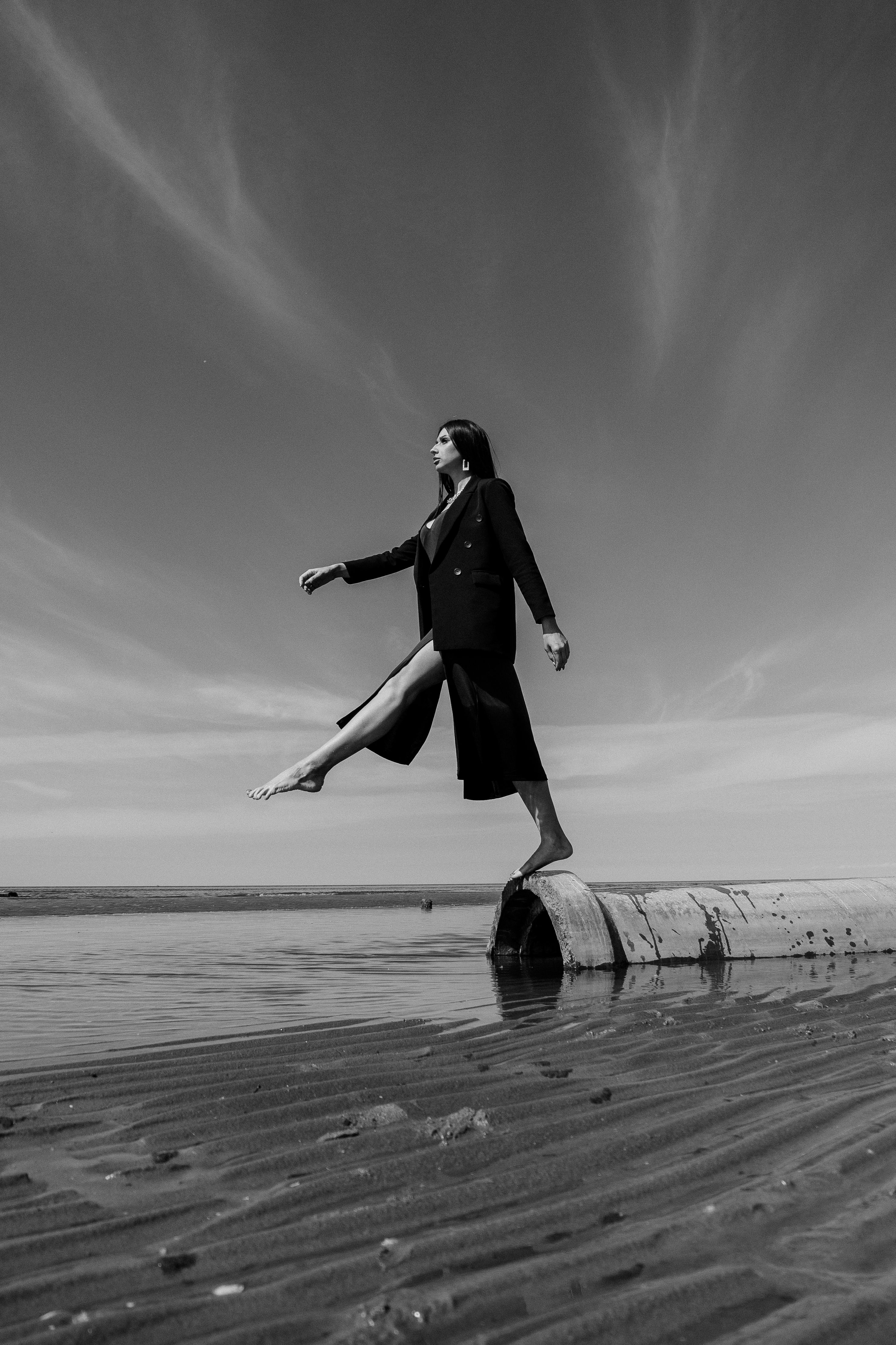 Woman Sitting on a Beach in Black and White · Free Stock Photo