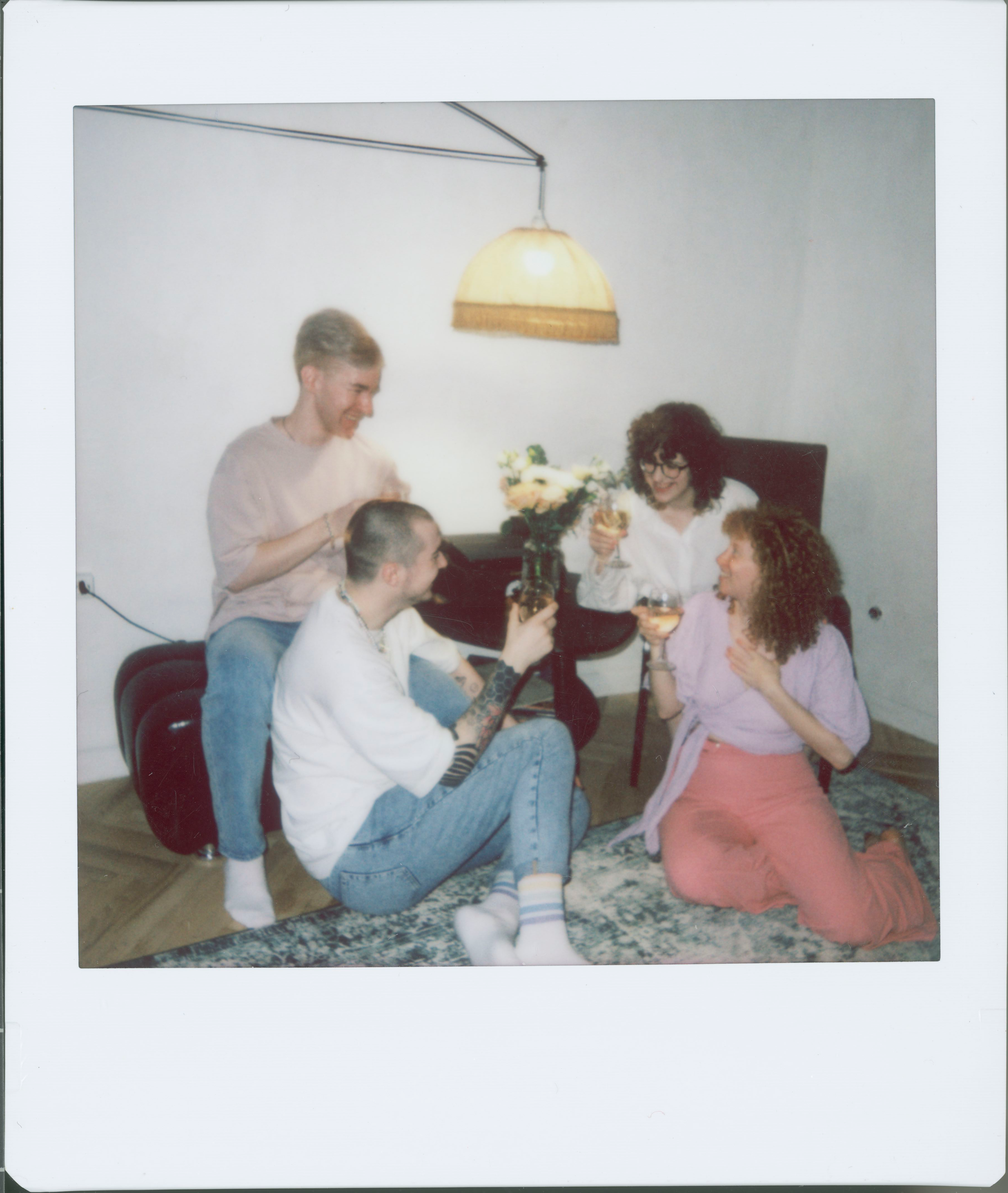 A group of friends enjoying drinks together in a cozy room.