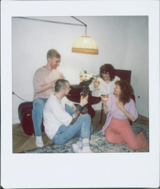 A group of friends enjoying drinks together in a cozy room.