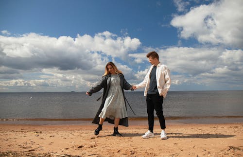 A Couple Holding Hands near the Sea