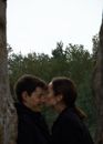 Man and Woman Kissing Near Brown Tree