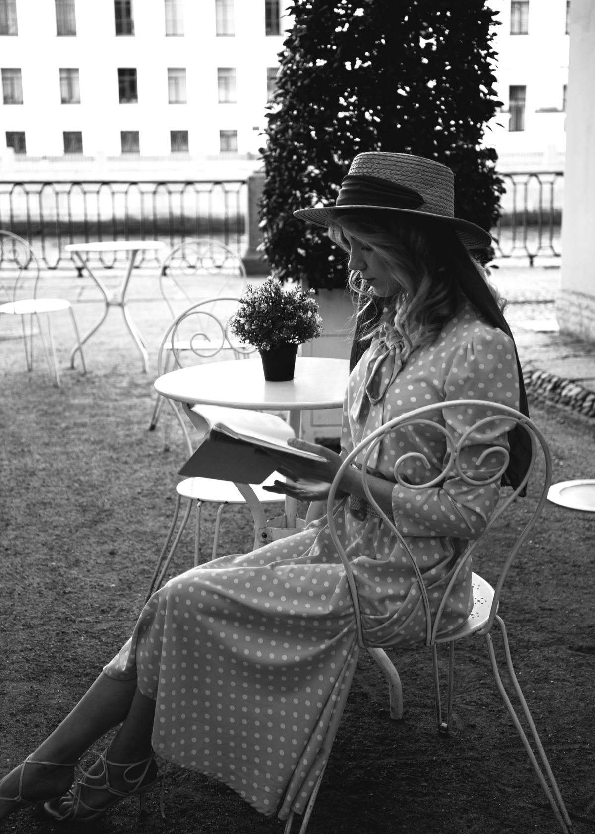 A woman in a polka dot dress and hat sitting on a chair — the joyful side of the dot
